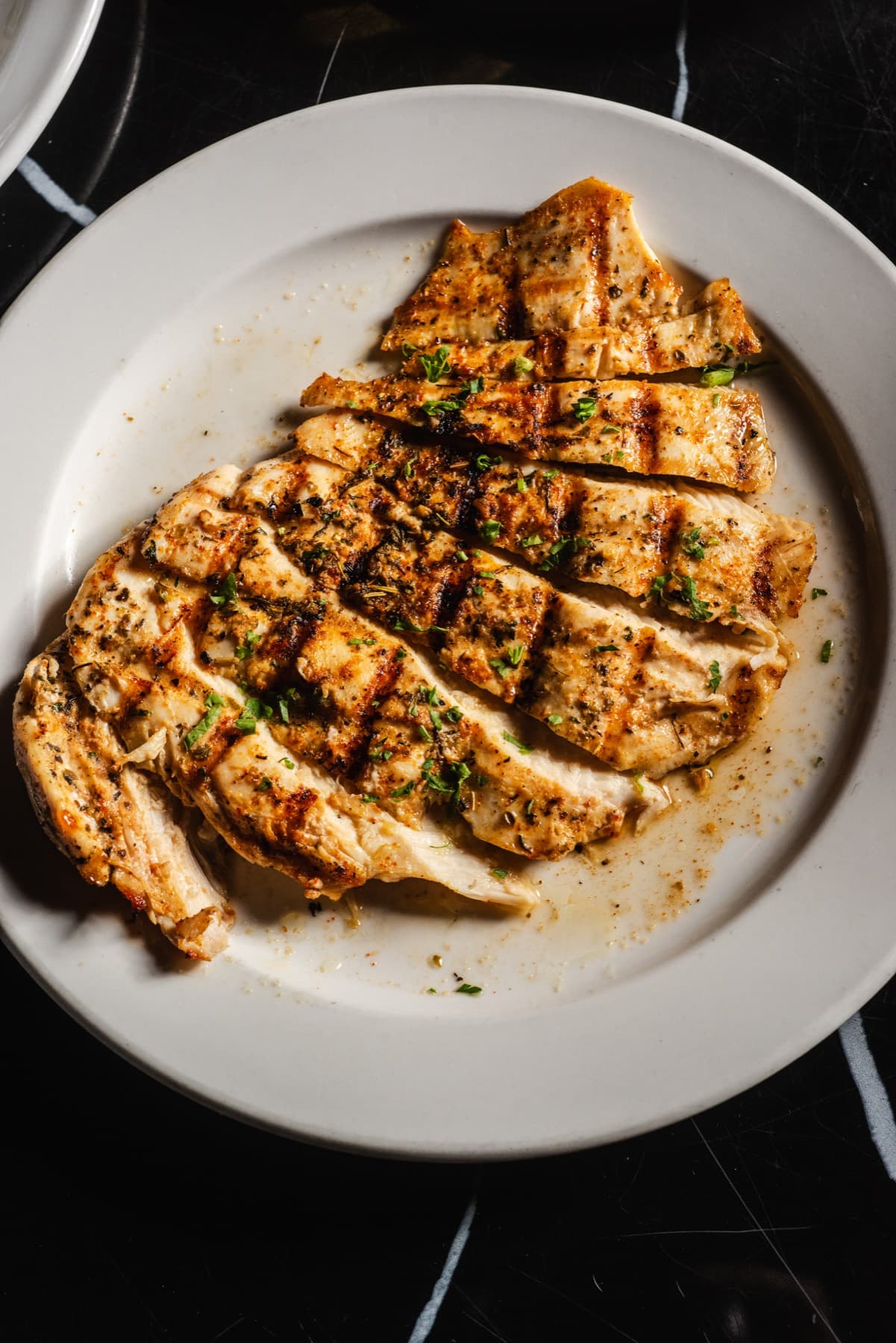 Herb grilled chicken served on a white plate